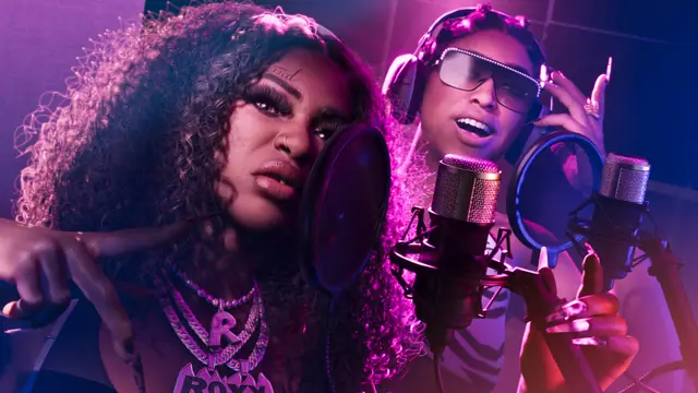 Dos cantantes grabando en un estudio con luces rosas y azules